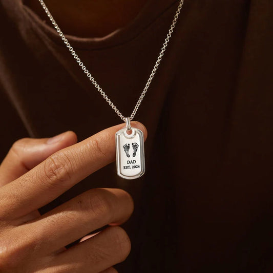 Man holding custom silver dad necklace with baby footprint engraving | Mrs Gift